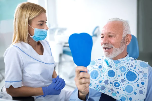 patient senior qui discute avec un dentiste