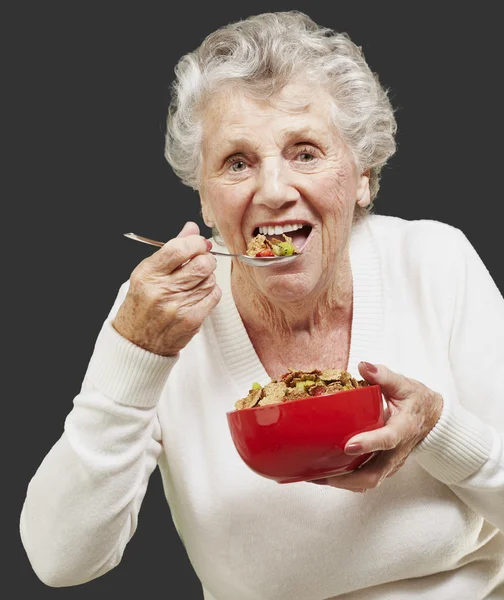 femme senior qui mange avec ses belles dents